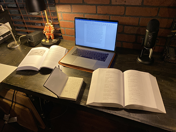 Orlando Vincente's work space; laptop and open books on a desk