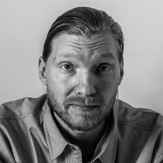 Juuso Tervo looking directly into the camera, eyebrows raised, mustache and beard