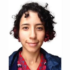 Nasrin smiling at the camera, short curly hair, head-and-shoulders