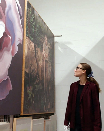 Person in profile looking up at a large painting