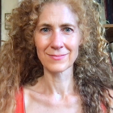 Erin Manning smiling at the camera, long curly brown hair