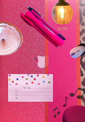 Hot pink-colored desktop with drink, pens and notepad