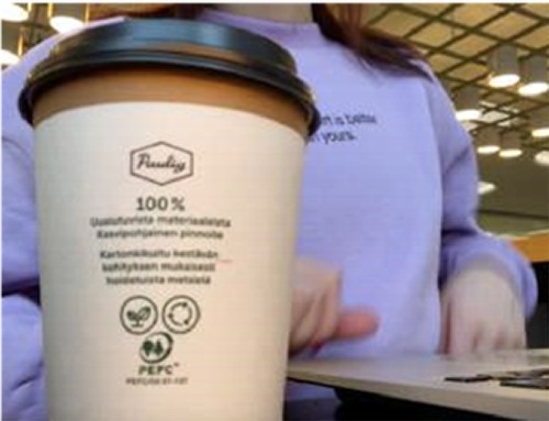 paper coffee cup with person in the background
