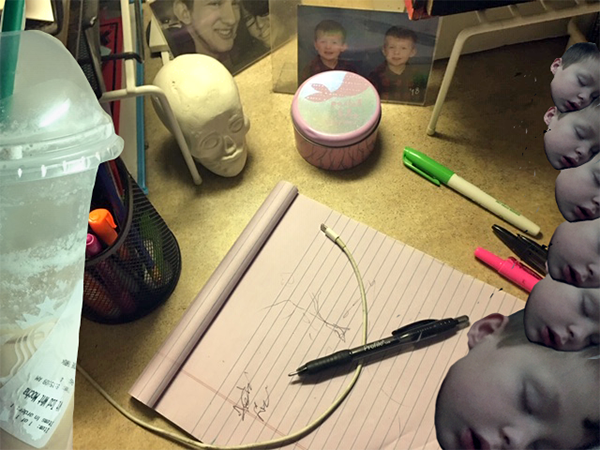 Cluttered desktop with a drink, ceramic skull, photos, paper and pen