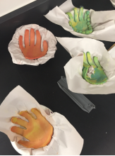 Image of four completed handprint sculptures displayed on table.